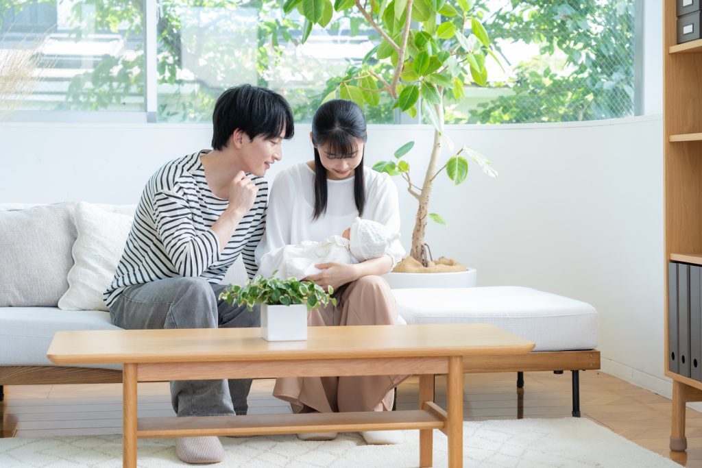 リビングで赤ちゃんを抱っこする夫婦