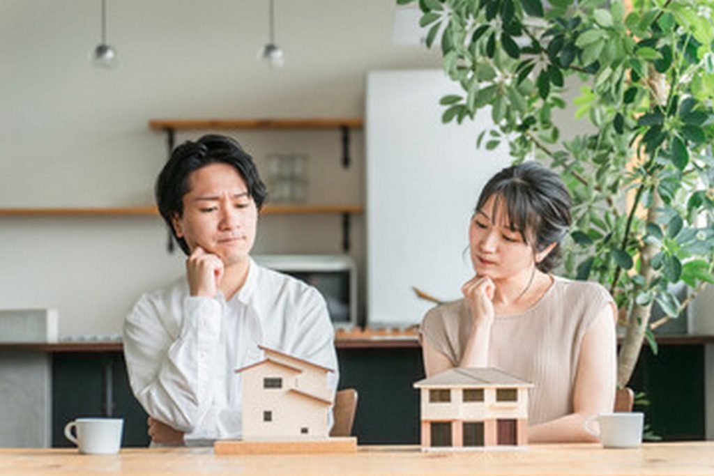 住宅の模型を見て考える夫婦